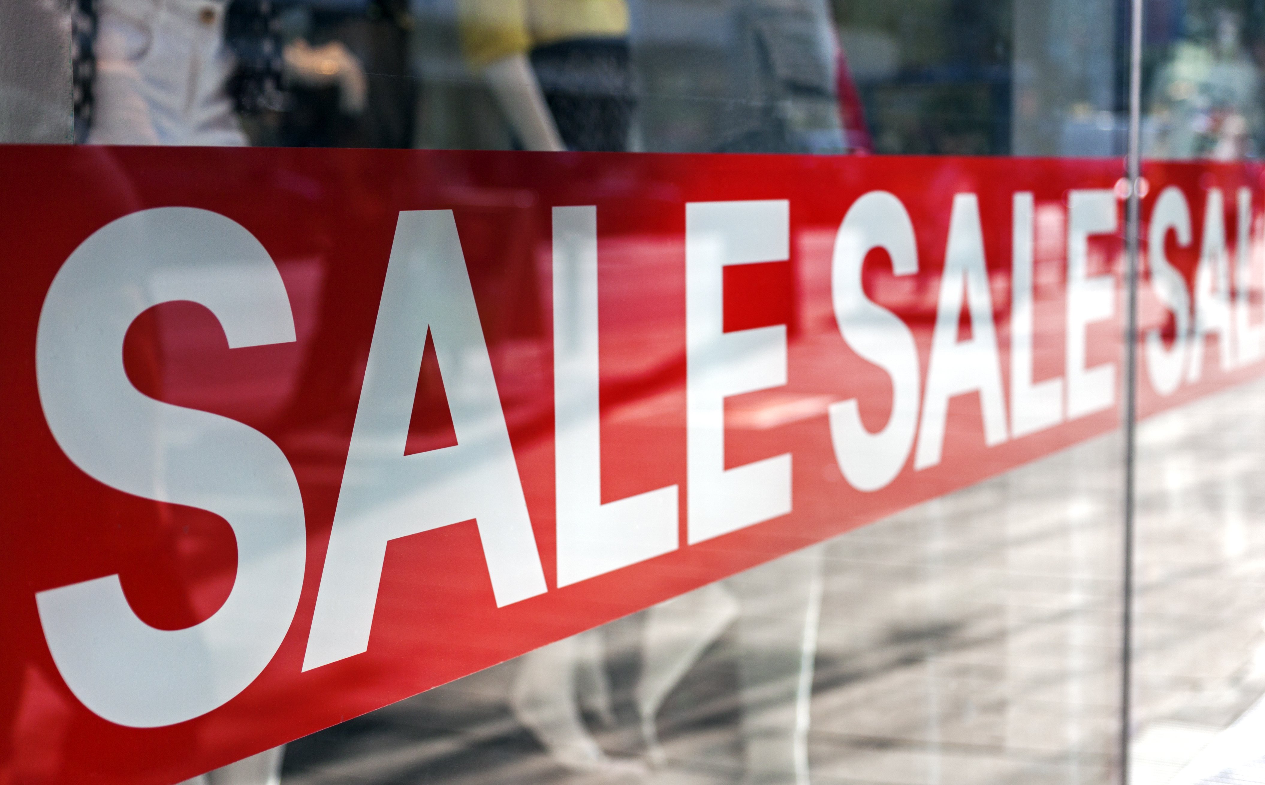 Picture of shop window display with text Sale on red poster