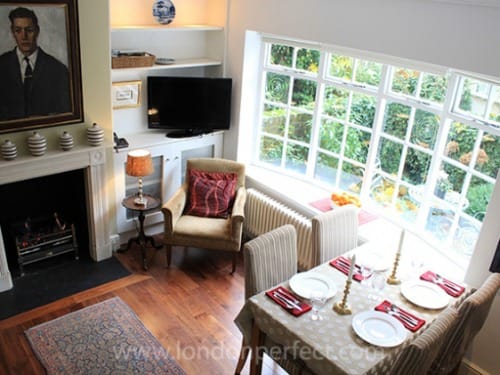 The charming living room with large window overlooking private entrance garden