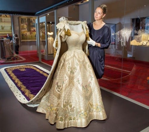 Exhibition curator Caroline de Guitaut adds the finishing touches to the display of The Queen's Coronation Dress and Robe. Photo from the Royal Collection.
