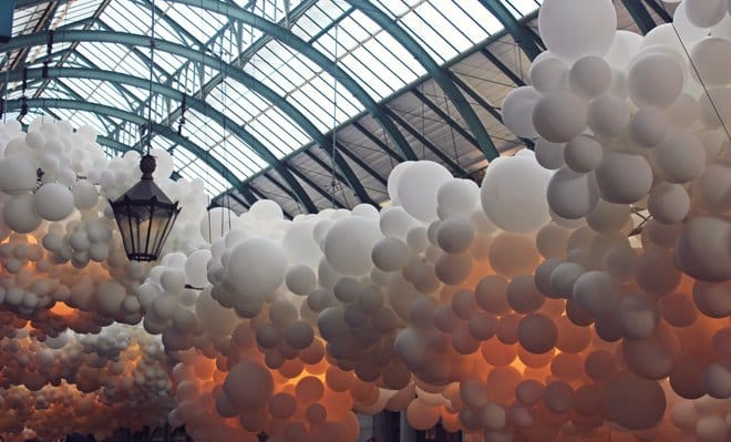 The moodily lit balloons give an atmospheric feel to domed ceiling of London's Convent Gardens Market Hall.